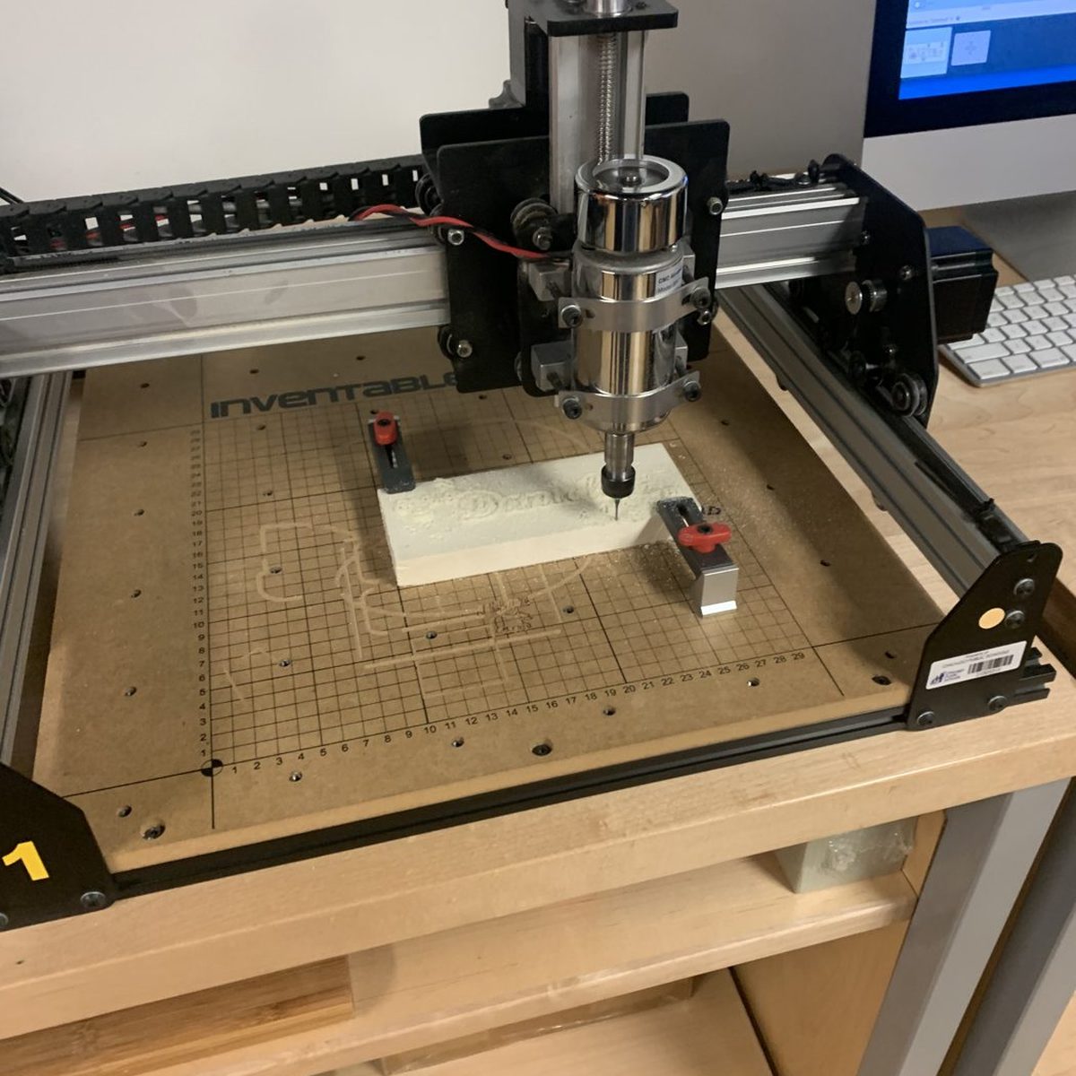 Block of aspen wood clamped onto the bed of an X-Carve CNC carving machine before carving