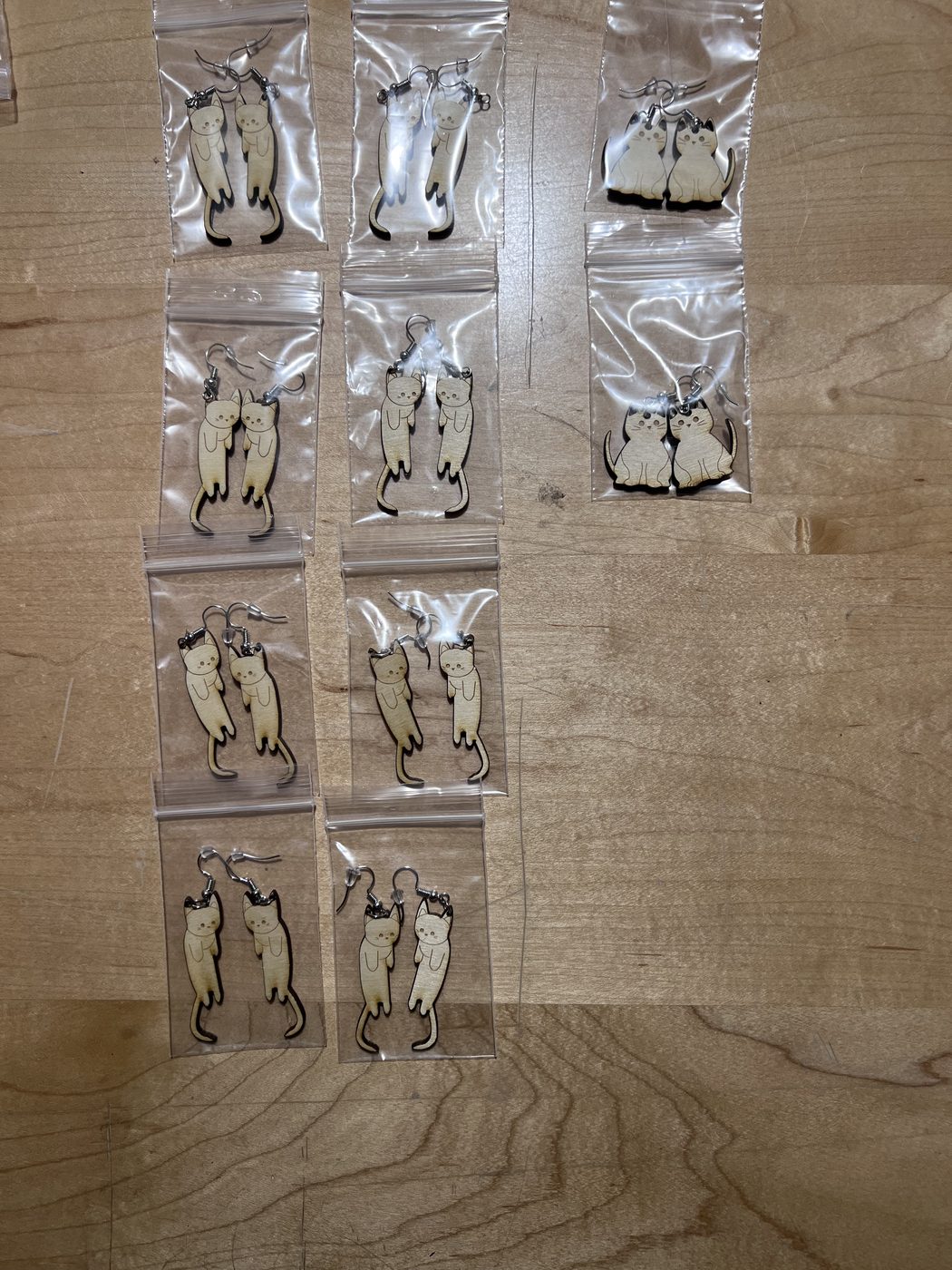 Finished cat earring pairs packaged in small bags, ready to sell at the Makers Lab fundraiser